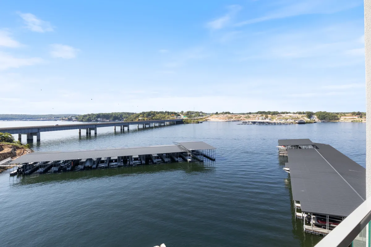 A sweeping view of marina docks with calm water, a bridge in the background, and open spaces for boating or fishing. The scene is lively yet tranquil, embodying the essence of lakeside recreation.